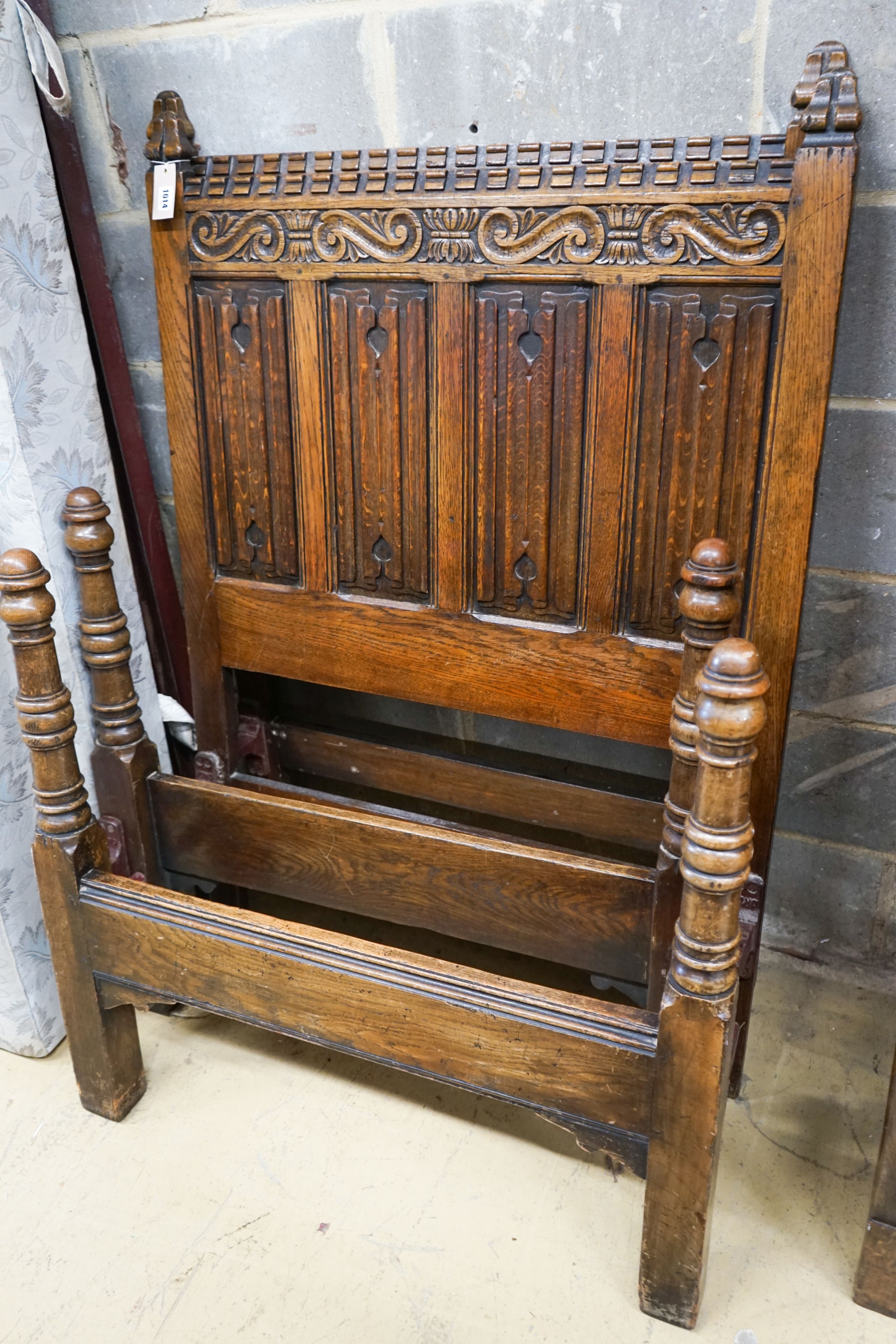 A 17th century style carved and panelled oak triple wardrobe with linenfold decoration, and a pair of early 20th century revival linenfold carved single bedframes, width 91cm, height 130cm